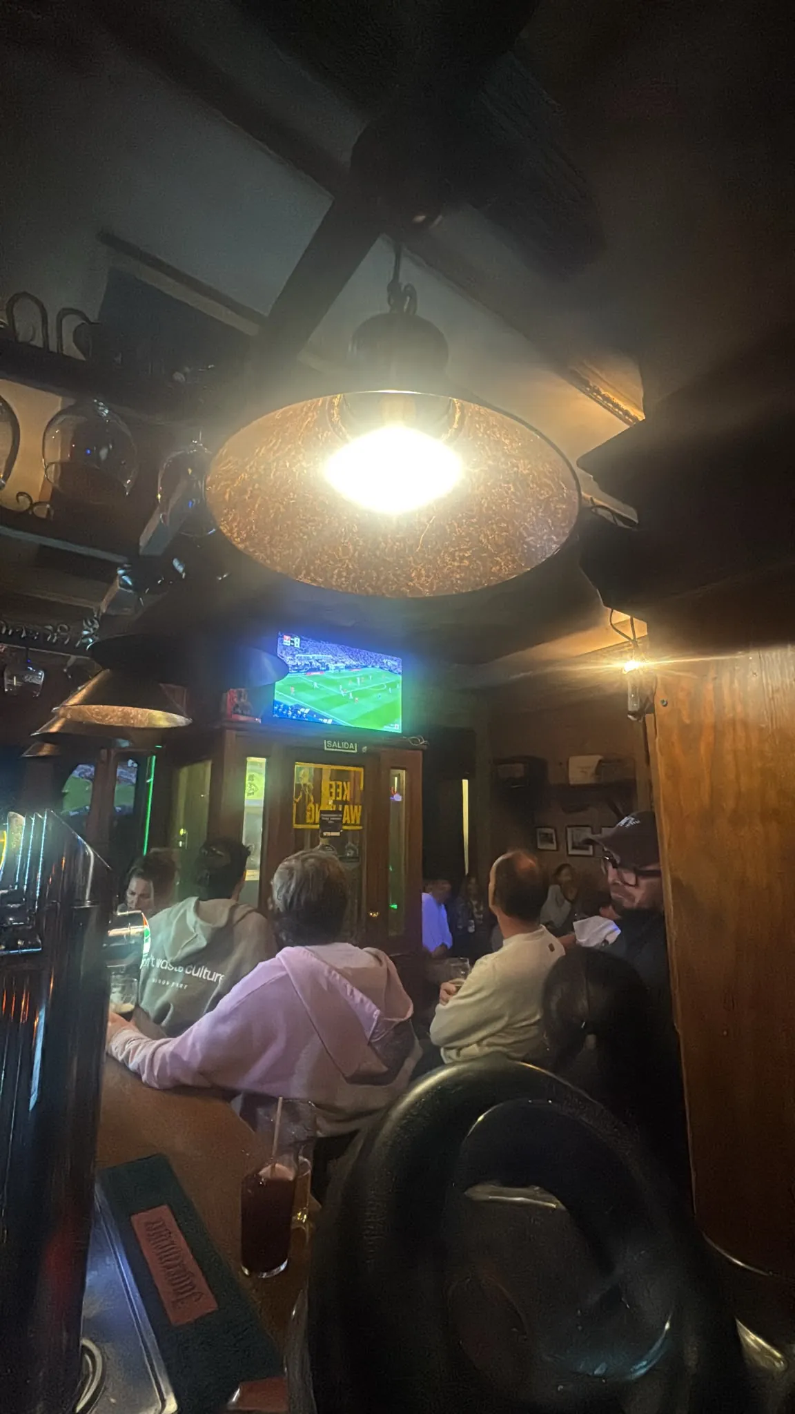 Bar counter and a TV screen inside Dubliners Madrid