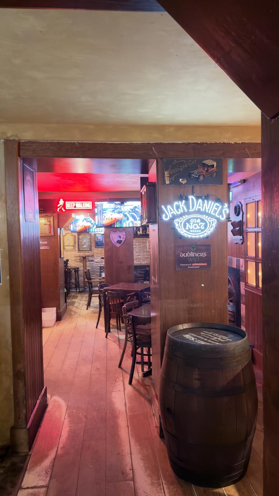 Seating doorway with neon and TVs at Dubliners
